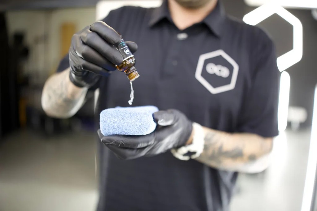 OCD technician applying Owner's Pride ceramic coating to a microfiber applicator