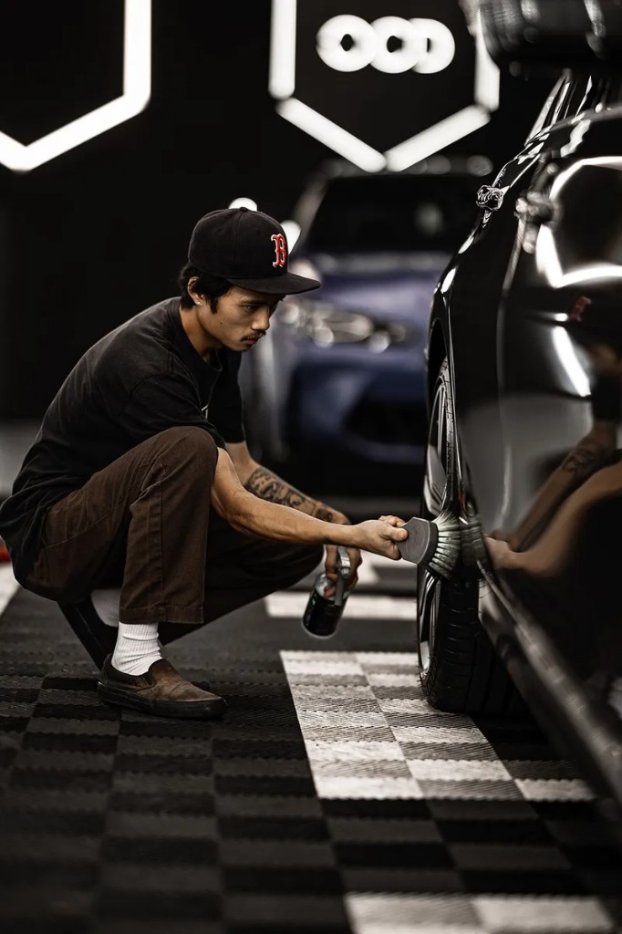OCD technician deep-cleaning a wheel and tire in the studio