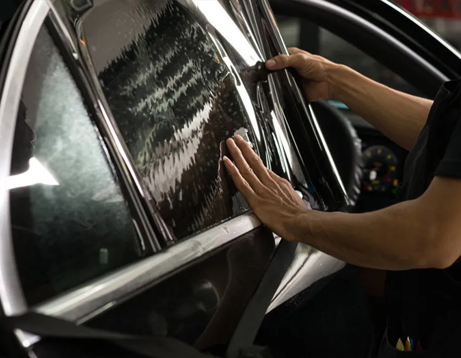 OCD technician installing 3M window tint film on a vehicle